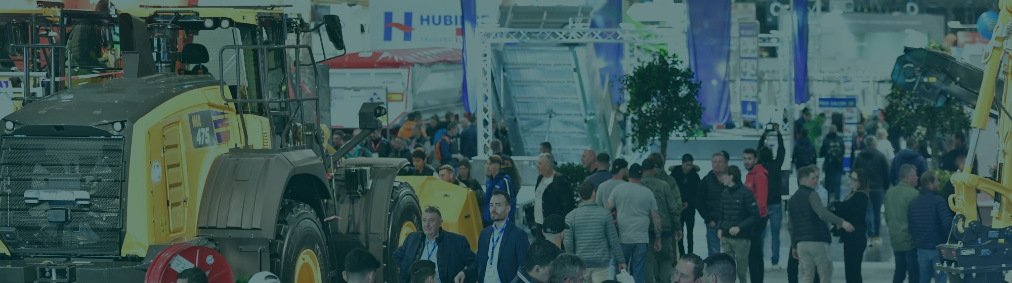 Interior aisle of the Intermat exhibition with visitors and displayed machinery.